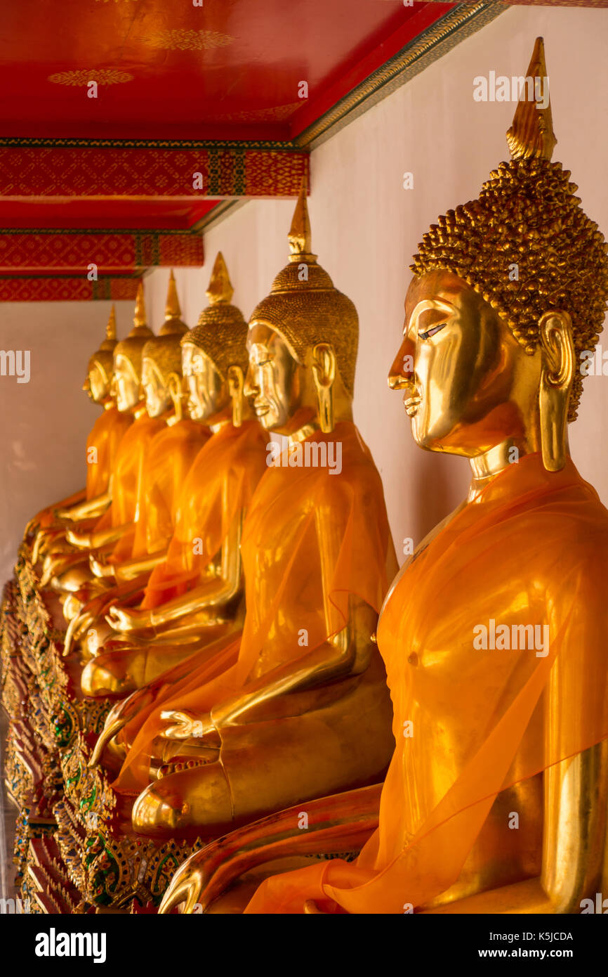 Fila di seduta statue di Buddha all'interno di Wat Pho o il Tempio del Buddha reclinato, bangkok, Thailandia Foto Stock