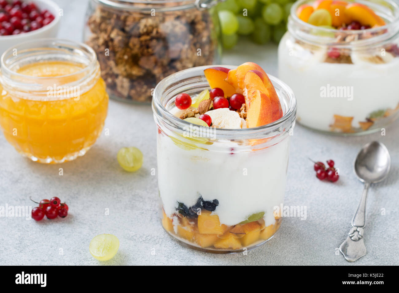 Lo yogurt naturale con frutta fresca e bacche e oat granola in barattolo. sana colazione Cibo, dieta lifestyle fitness concetto. primo piano Foto Stock