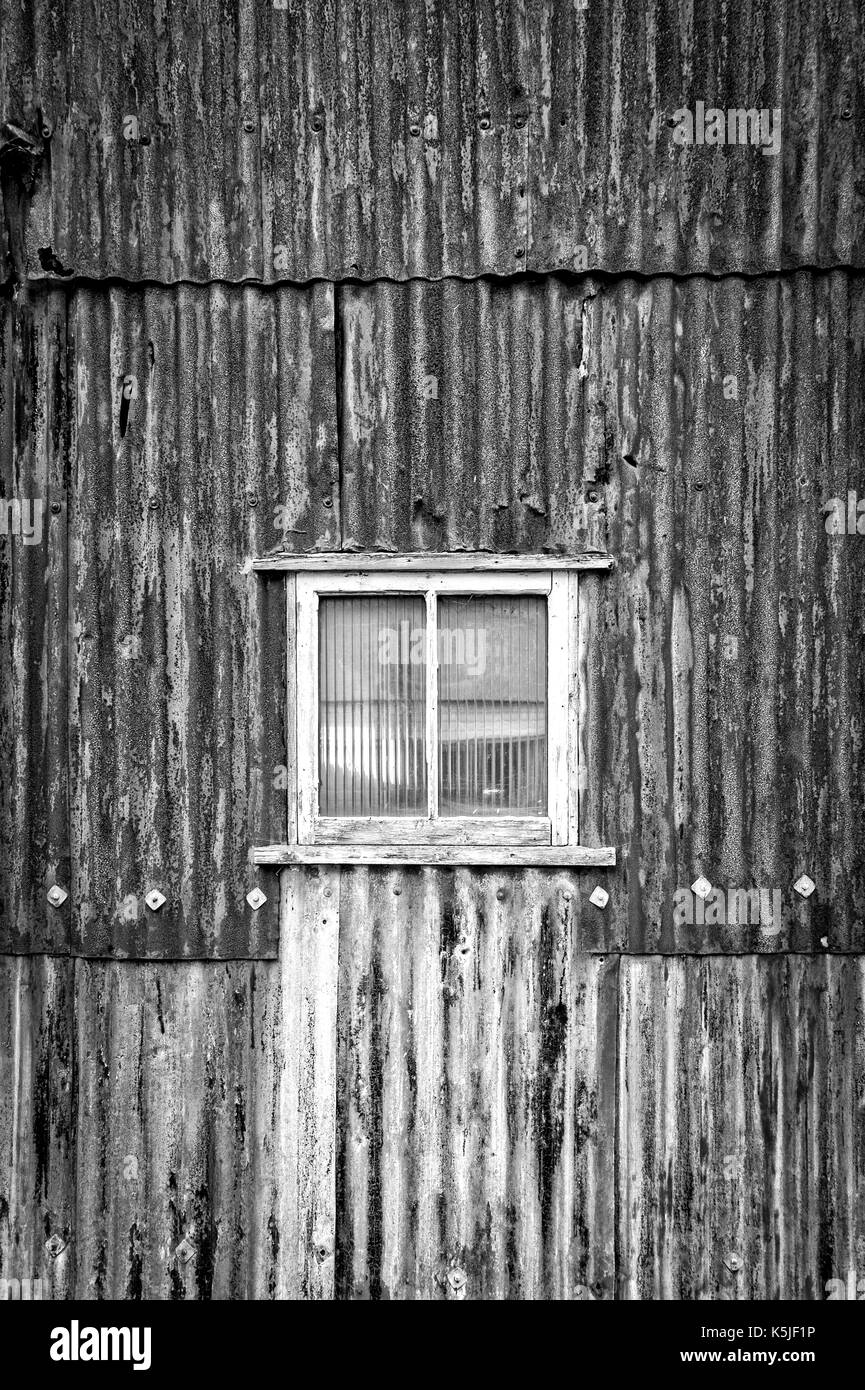 Rusty ferro corrugato edificio, magazzino con finestra. Foto Stock