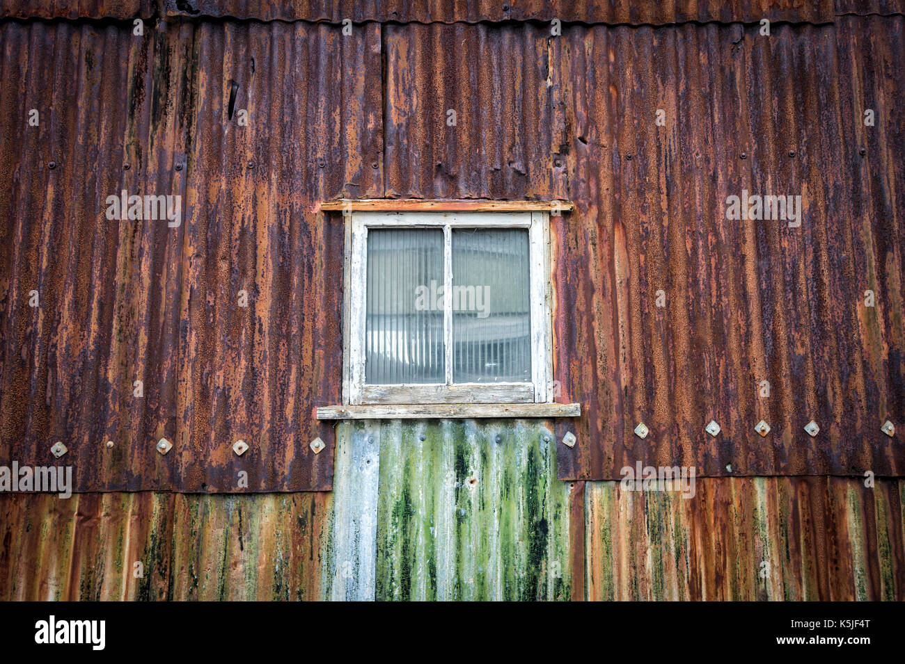 Rusty ferro corrugato edificio, magazzino con finestra. Foto Stock