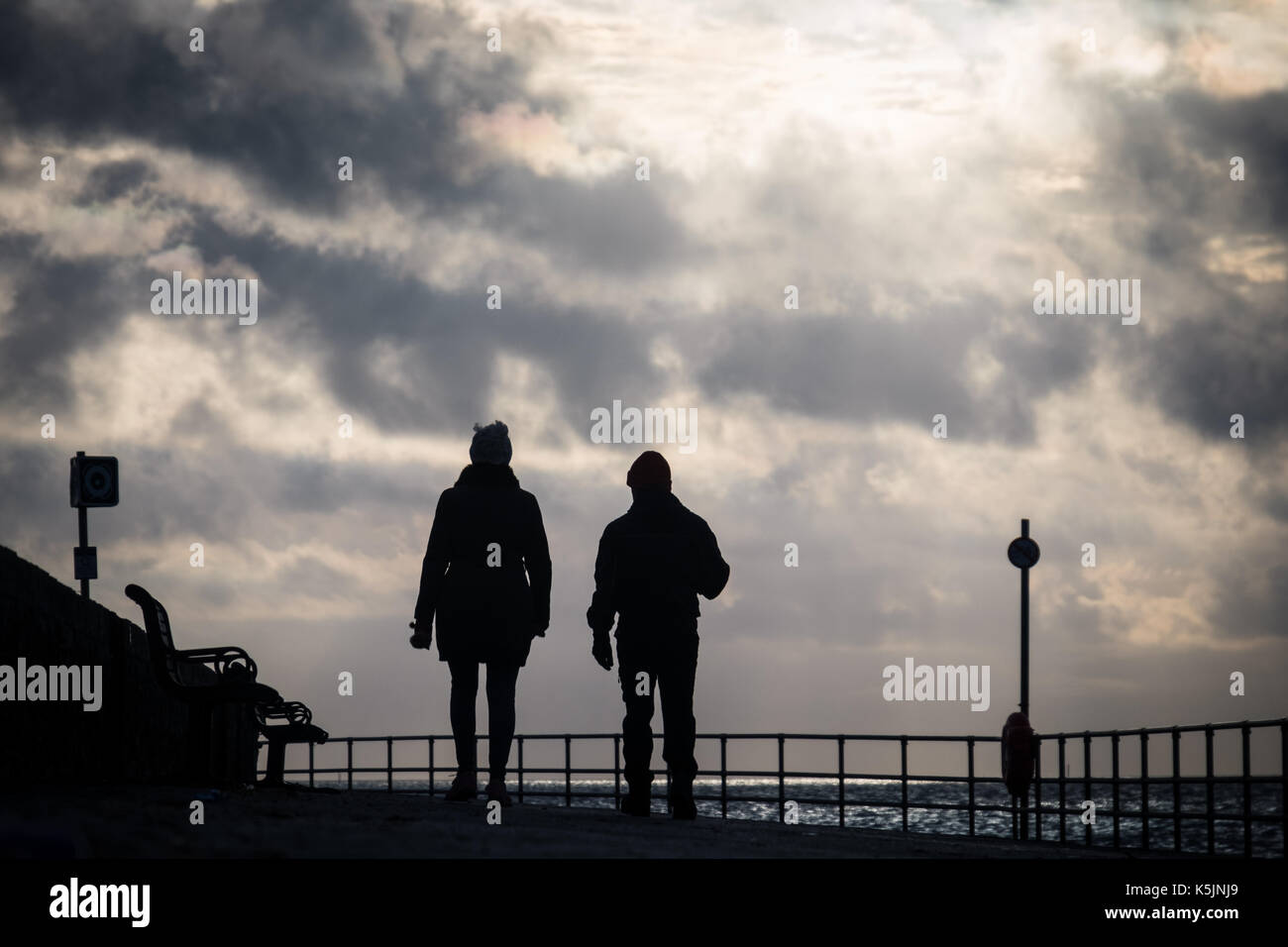 Le persone che assumono una mattina inverno a piedi lungo il Southsea promenade Foto Stock