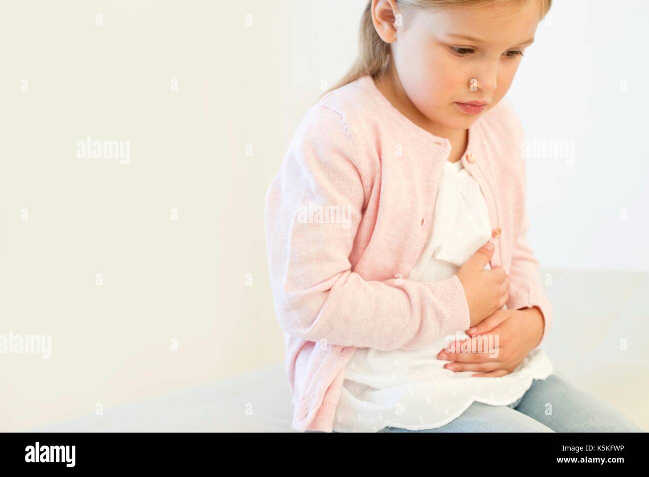 Ragazza giovane con il mal di stomaco. Foto Stock