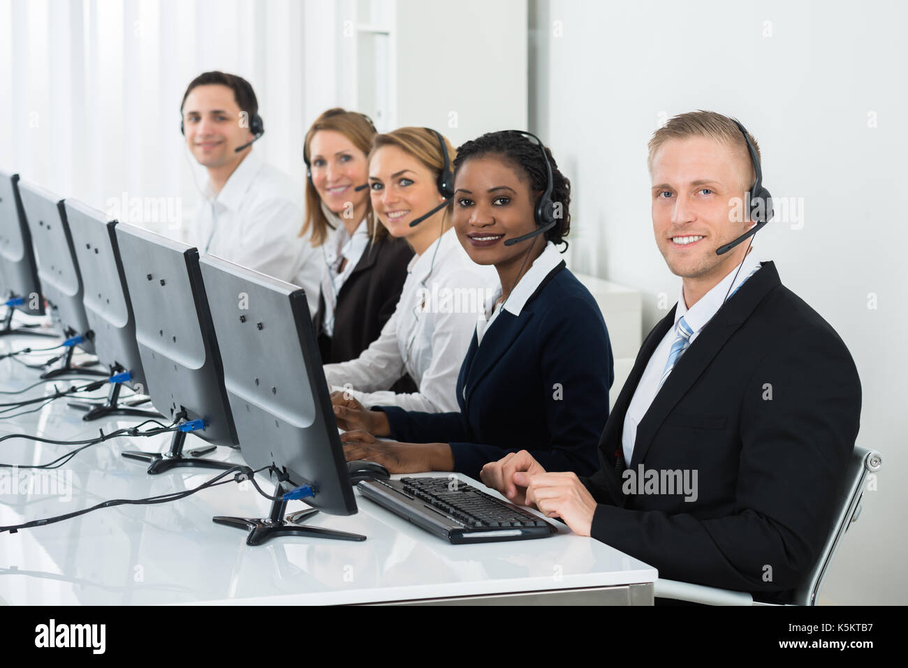 Il team di operatori con cuffie lavorano nei call center office Foto Stock