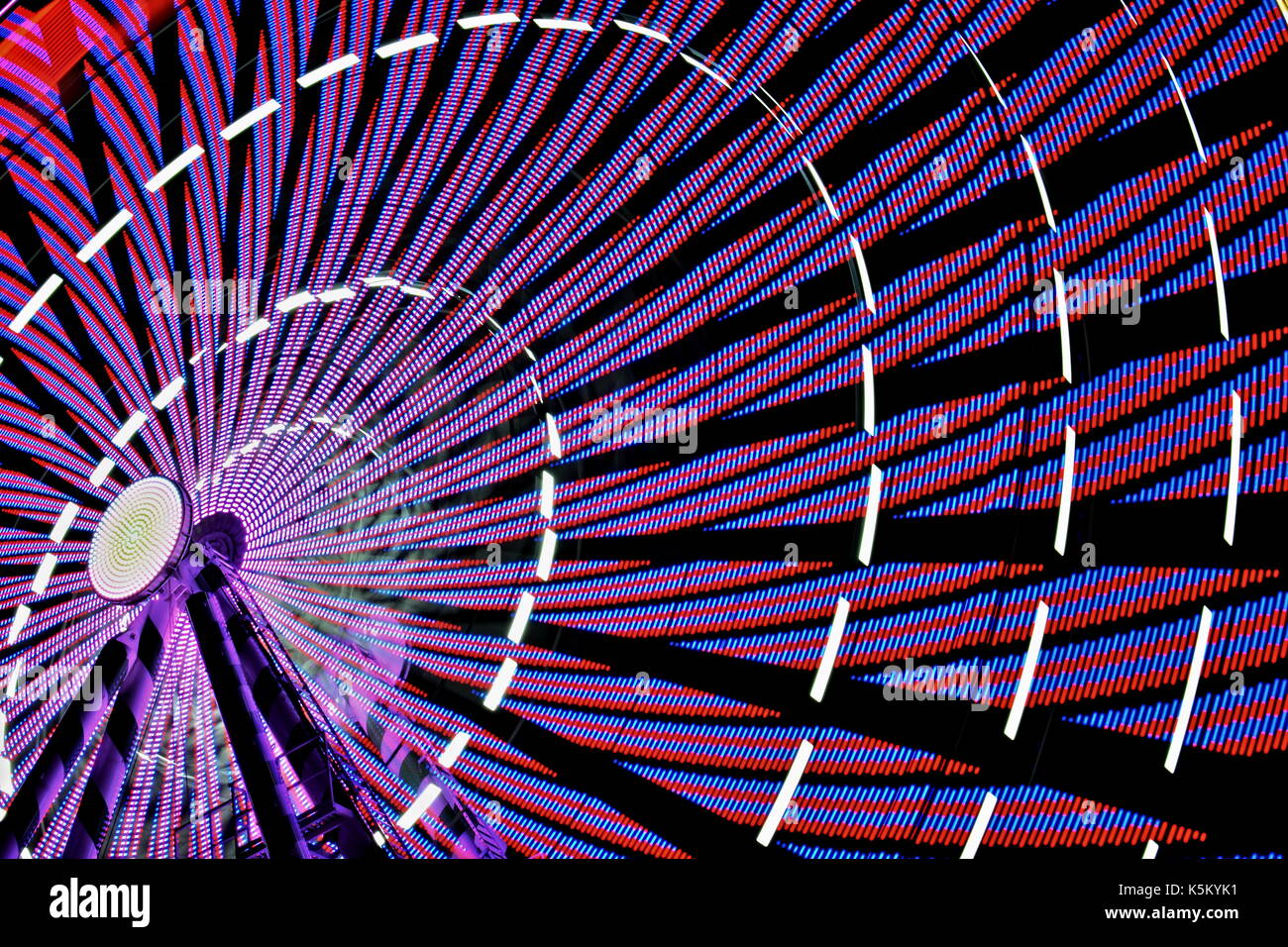 Una lunga esposizione fotografia di una ruota panoramica Ferris di notte Foto Stock