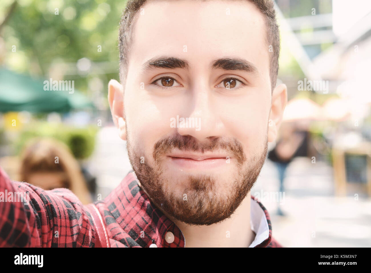 Giovane uomo latino tenendo un selfie. scena urbana. all'esterno. Foto Stock