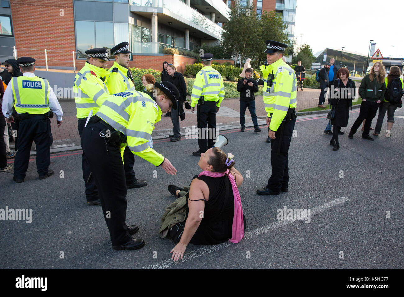 Londra, Regno Unito. Il 9 settembre, 2017. Un funzionario di polizia chiede una donna per cancellare la strada utilizzata per effettuare le consegne al centro ExCel per la prossima settimana al Salone DSEI arms fair. DSEI è la più grande fiera di armi militari e delegazioni invitate dal governo britannico includono membri nominati dal Ministero degli esteri come un "diritti umani priorità', vale a dire il Bahrein, Colombia, Egitto, Pakistan e Arabia Saudita. Credito: Mark Kerrison/Alamy Live News Foto Stock