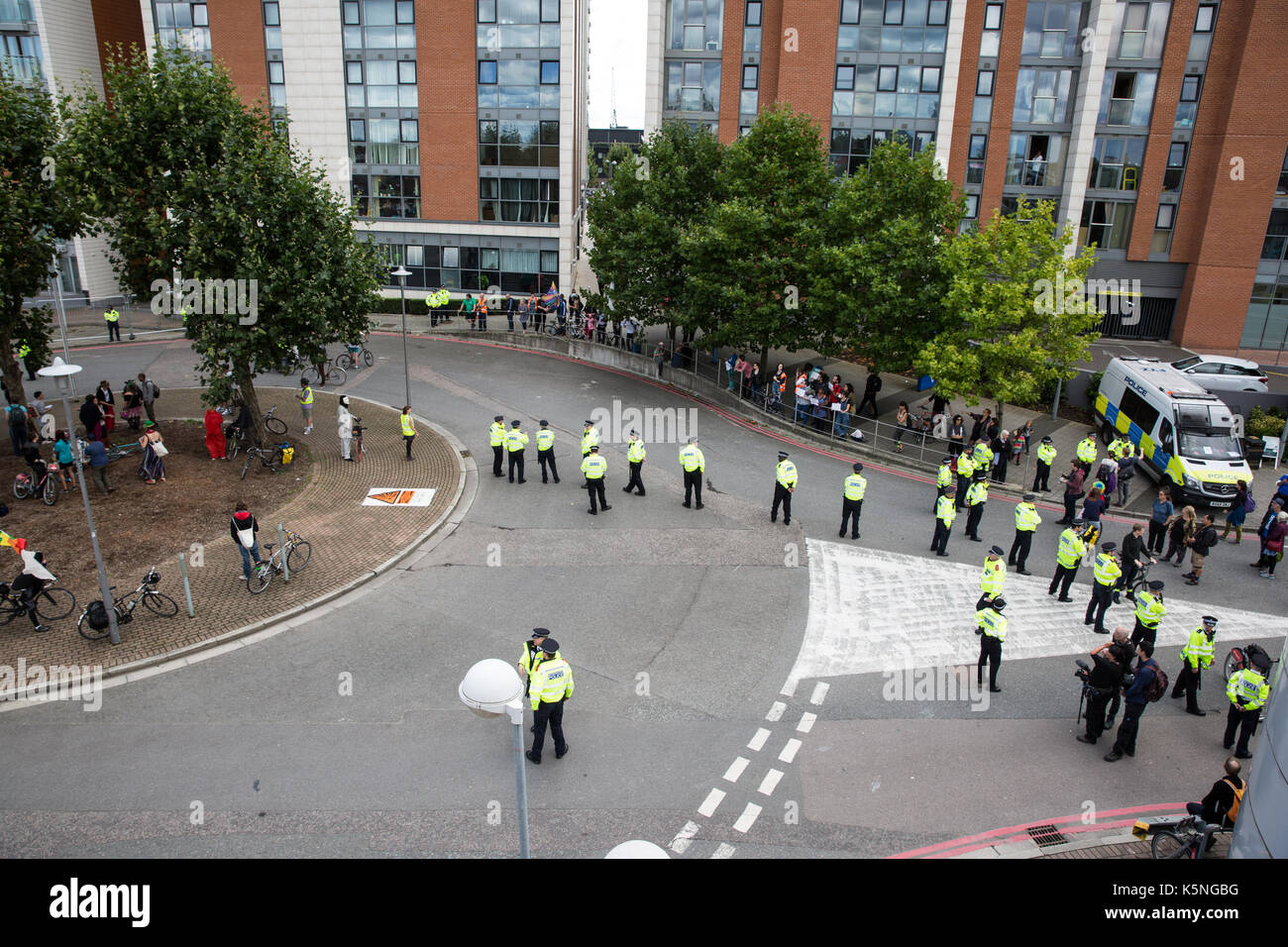 Londra, Regno Unito. Il 9 settembre, 2017. Gli ufficiali di polizia la linea fino a mantenere un accesso chiaro su strada per le forniture di attrezzature militari per la prossima settimana al Salone DSEI arms fiera presso il centro ExCel. Gli attivisti provenienti da diverse campagne e gruppi di fede sono state protestando al di fuori del centro ExCel contro il commercio di armi e la fiera di armi che si terrà presso la sede della prossima settimana. DSEI è la più grande fiera di armi militari e delegazioni invitate dal governo britannico includono membri nominati dal Ministero degli esteri come un "diritti umani prioritario " , ossia il Bahrein, Colombia, Egitto, Pakistan e Arabia Saudita. Credito: Mark K Foto Stock