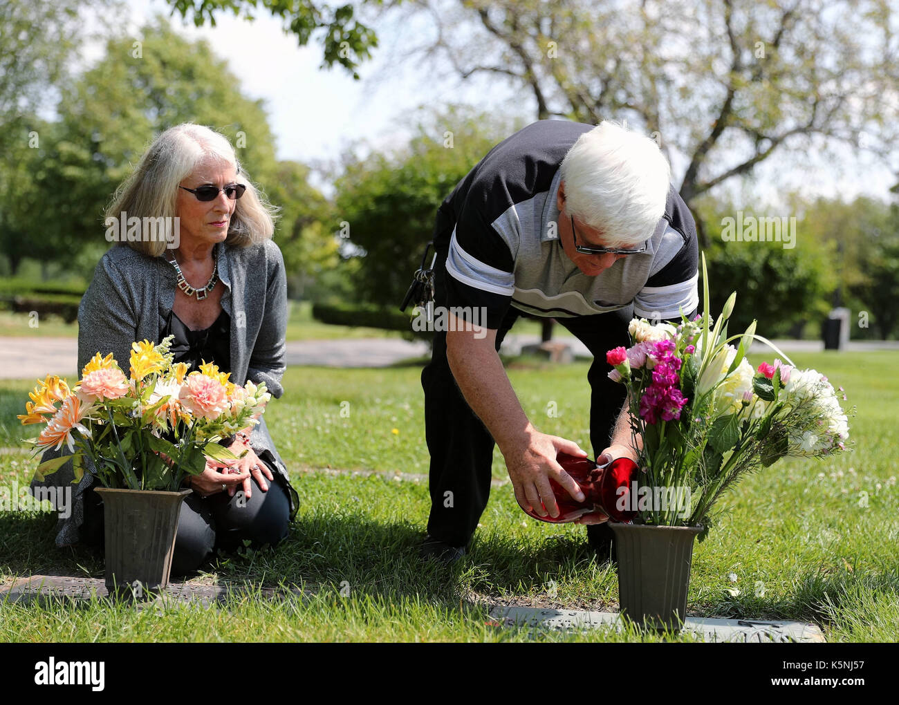 Chicago, Stati Uniti d'America. 18 agosto, 2017. William Brown (r), marito di gail cooper baumgartner-marrone, versa un po' di acqua nel vaso di fiori sulla tomba di gail il padre Joseph cooper nel quartiere di chicago, Stati Uniti su aug. 18, 2017. Per andare con xinhua includono: flying tigers soldato che non sarà mai dimenticato. Credito: wang ping/xinhua/alamy live news Foto Stock