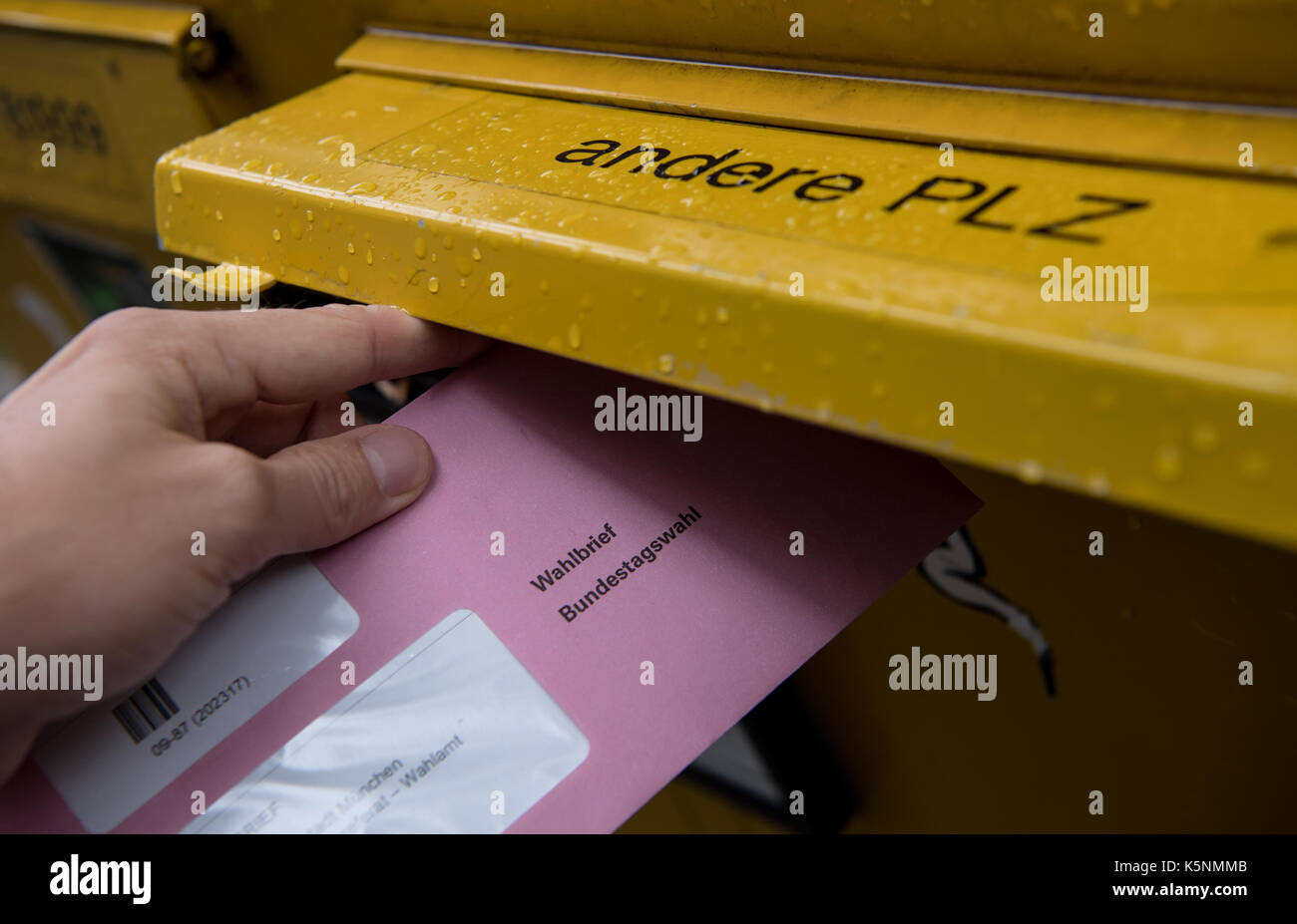 Illustrazione - un uomo getta i suoi documenti per le elezioni generali ("bundestagswahl') 2017 in una busta in una casella postale a Monaco di Baviera, Germania, il 10 settembre 2017. foto: sven hoppe/dpa Foto Stock