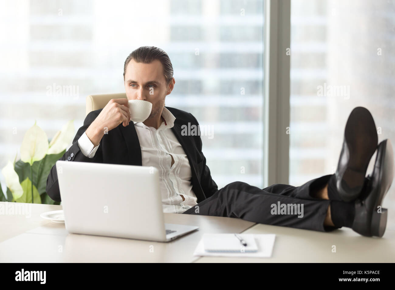 Imprenditore e rilassante di bere il caffè al lavoro in ufficio. Foto Stock