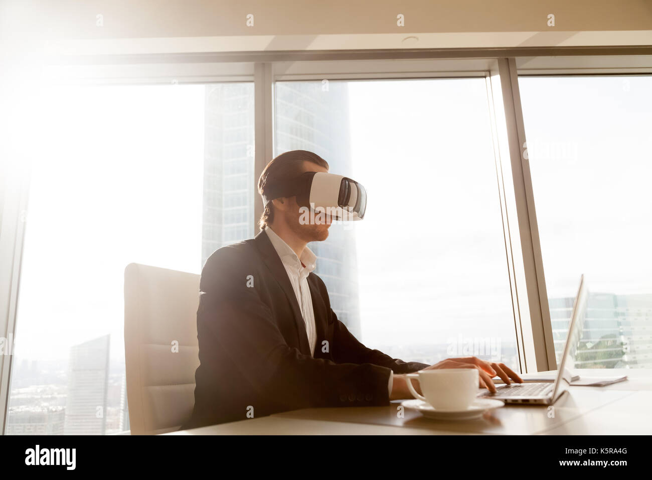 Imprenditore in vr auricolare effettuando test di applicazione sul compute Foto Stock