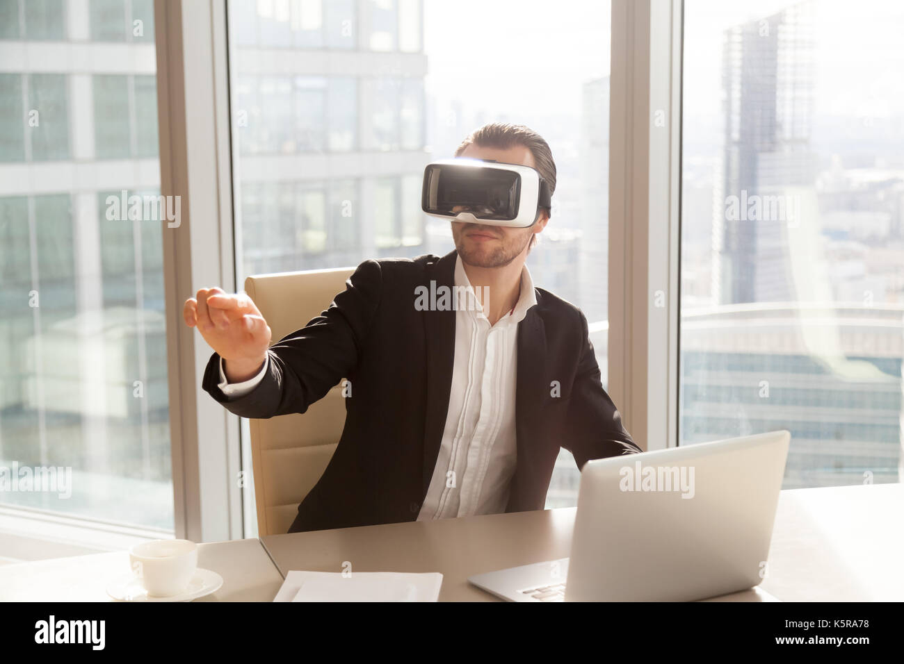 Lavoratore di ufficio in vr auricolare rivolto nell'aria. Foto Stock