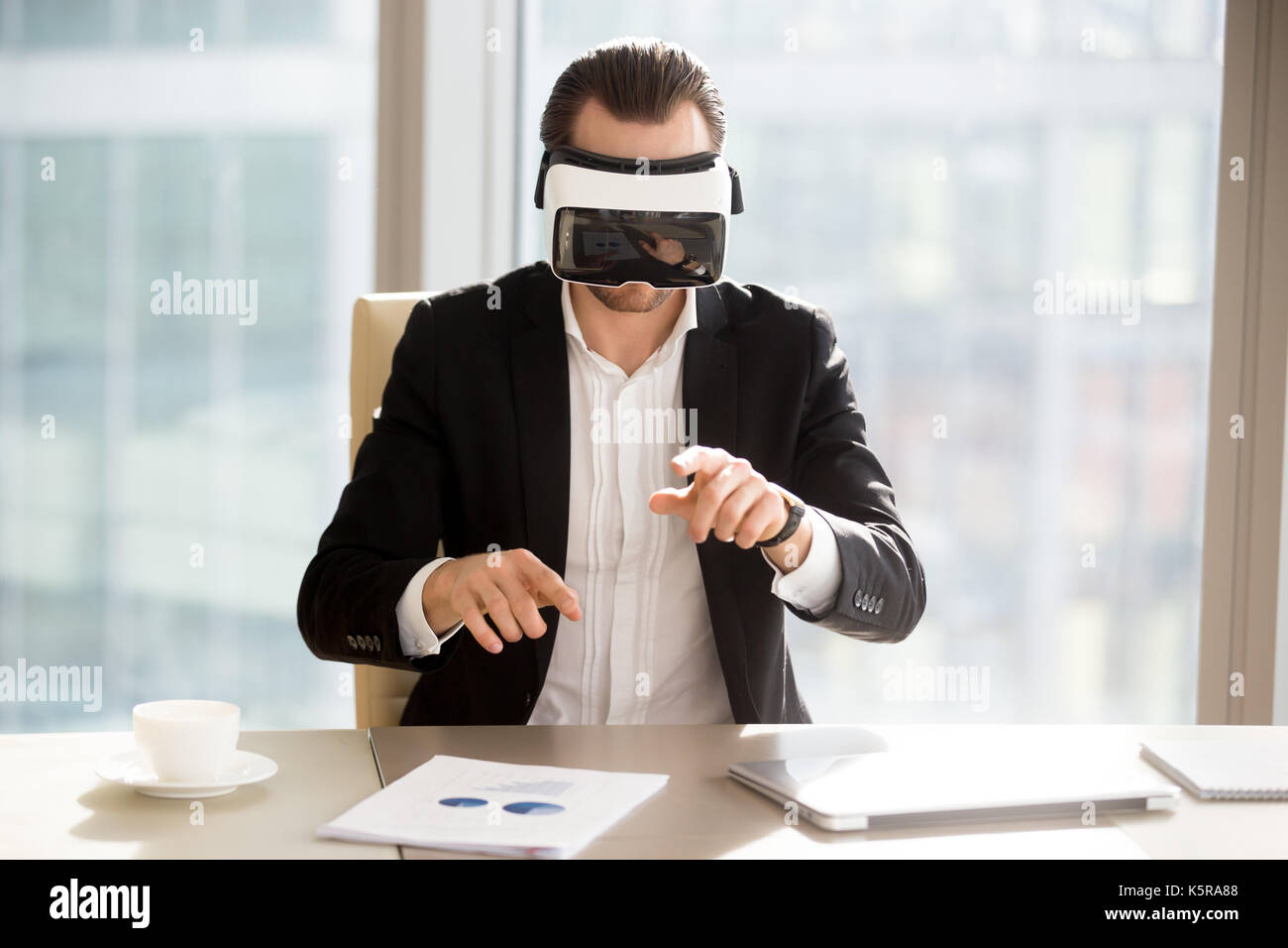 Imprenditore in vr uso della cuffia nella realtà aumentata in office Foto Stock