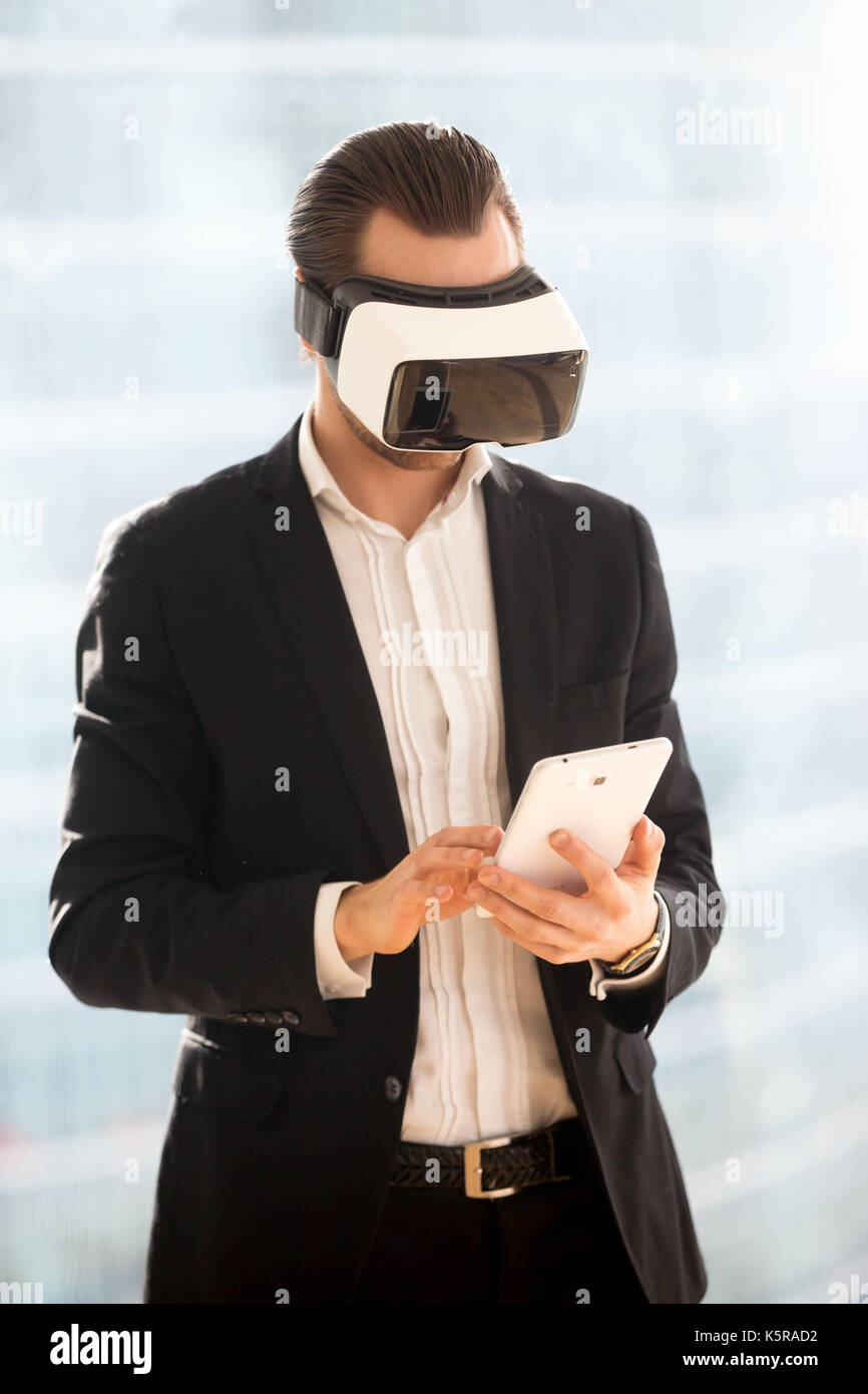 Imprenditore in occhiali vr lavorando sulla tavoletta elettronica. Foto Stock