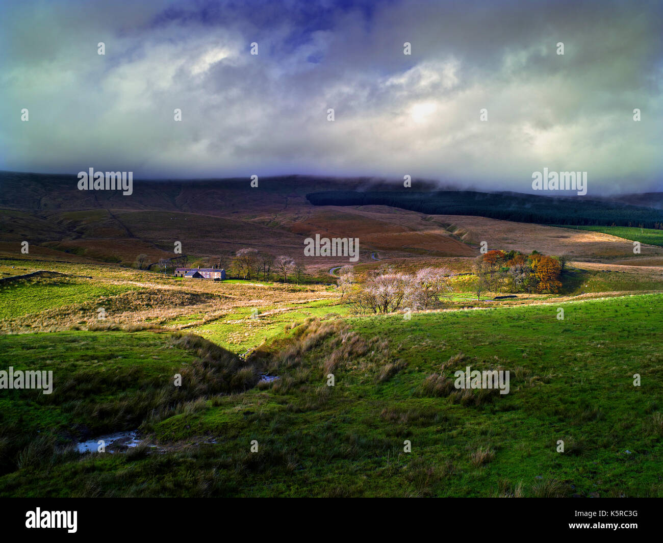 Una vista di Widdale in Wensleydale, North Yorkshire, come un raggio di sole si rompe in un cielo tempestoso Foto Stock