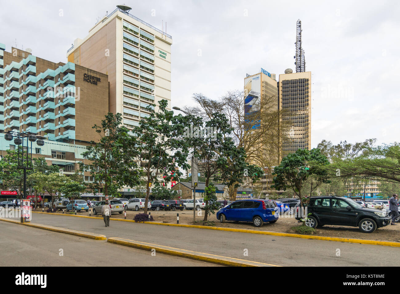 Grande parcheggio auto con veicoli parcheggiati con edifici in background, Nairobi, Kenia Foto Stock