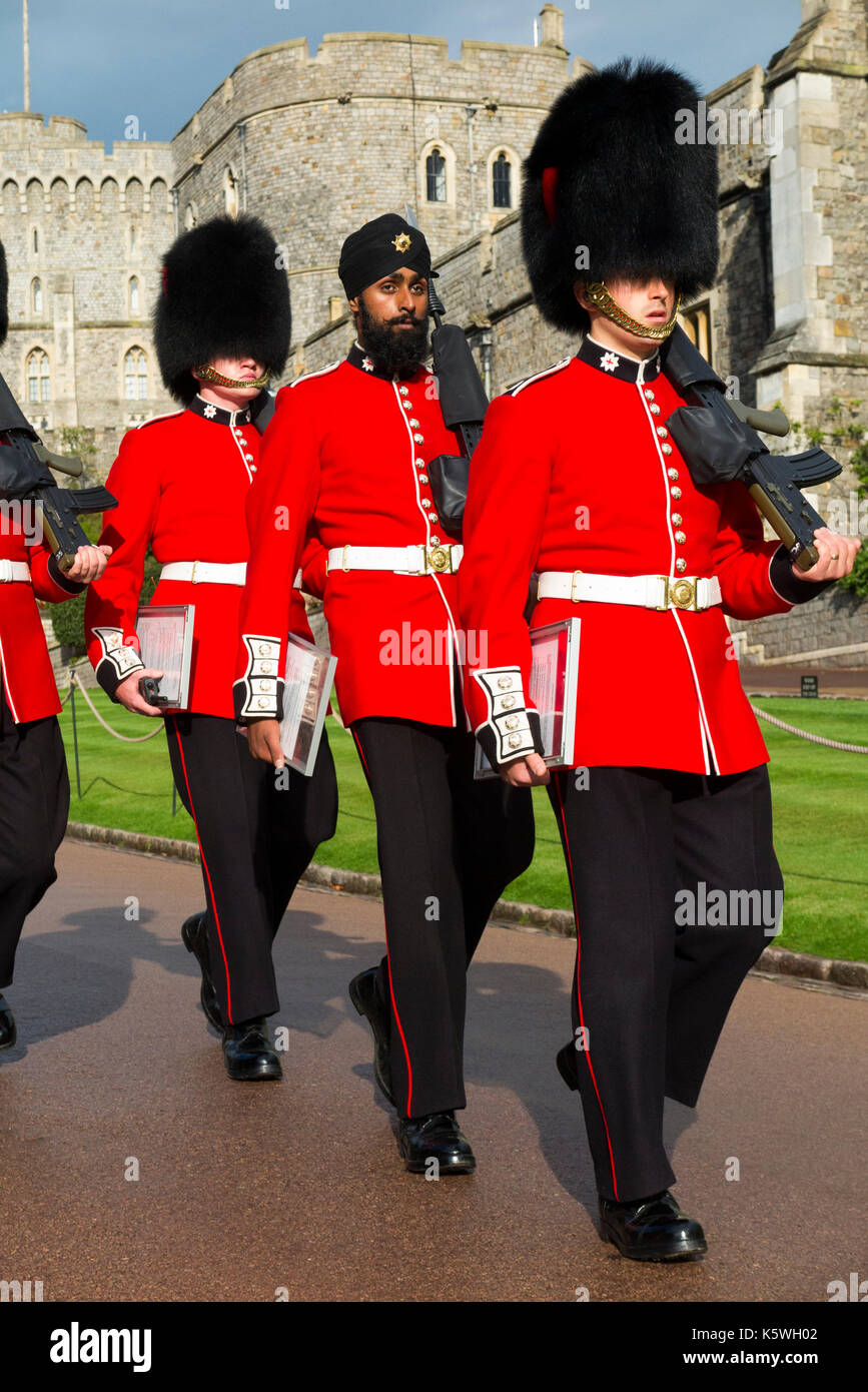 Esercito britannico soldati / Windsor Castle Guard ( Guardie Coldstream ) indossando il tradizionale uniforme rosso & Bearskin hat / Bearskins & turbante Sikh su Gdmn Lall. Foto Stock