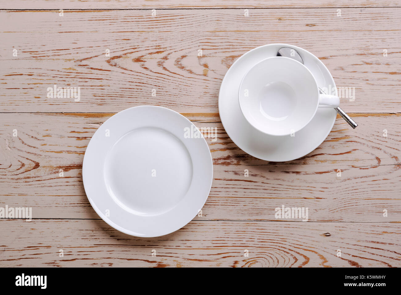 Tazza e piattino con piastra su distressed tavolo in legno. Foto Stock
