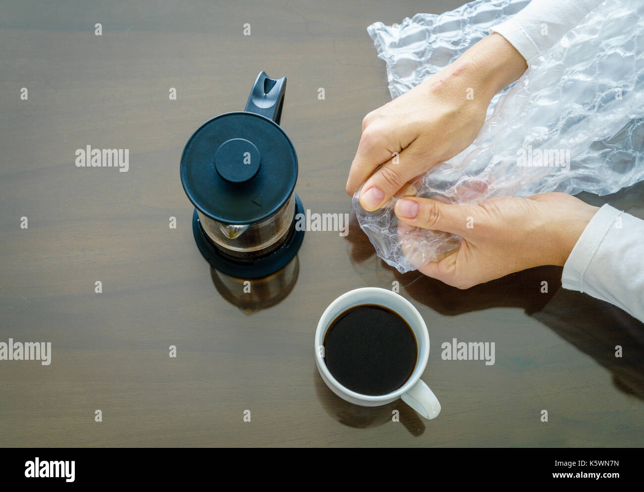 Close-up immagine di donna con le mani in mano popping Bubble wrap. vista da sopra Foto Stock