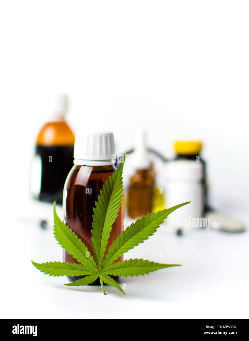 Foglia di marijuana e olio di cannabis bottiglie isolato su bianco Foto Stock
