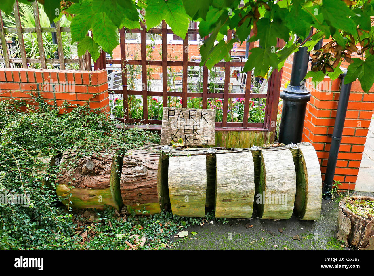 Parco ciclabile fatto di vecchio albero con segno scolpito che dice ''Park yer bike'' Foto Stock