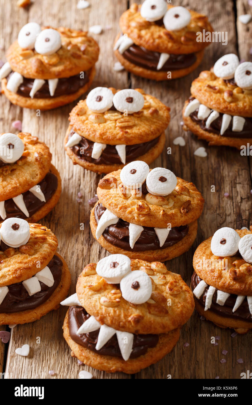 Halloween cibo: mostri di noce i biscotti con la crema di cioccolato vicino sul piano verticale. Foto Stock