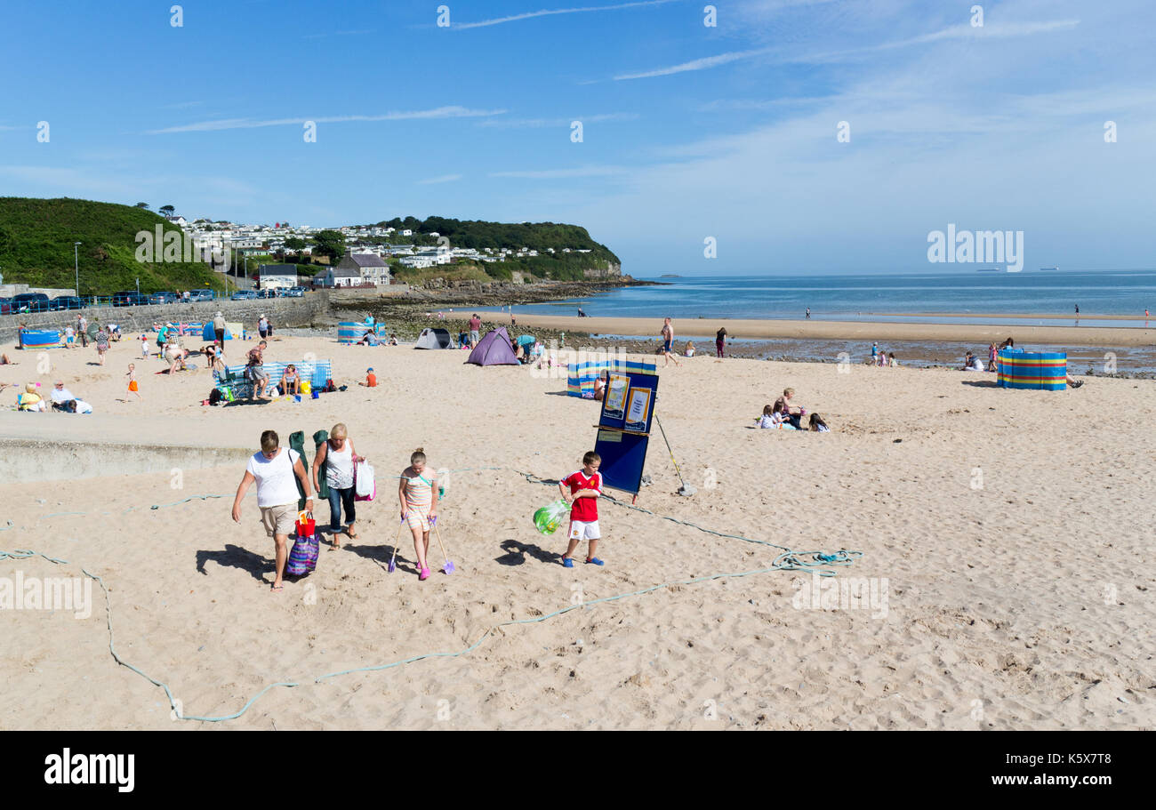Una famiglia proveniente dalla spiaggia a Benllech, Anglesey, Galles del Nord, Regno Unito, Gran Bretagna Foto Stock