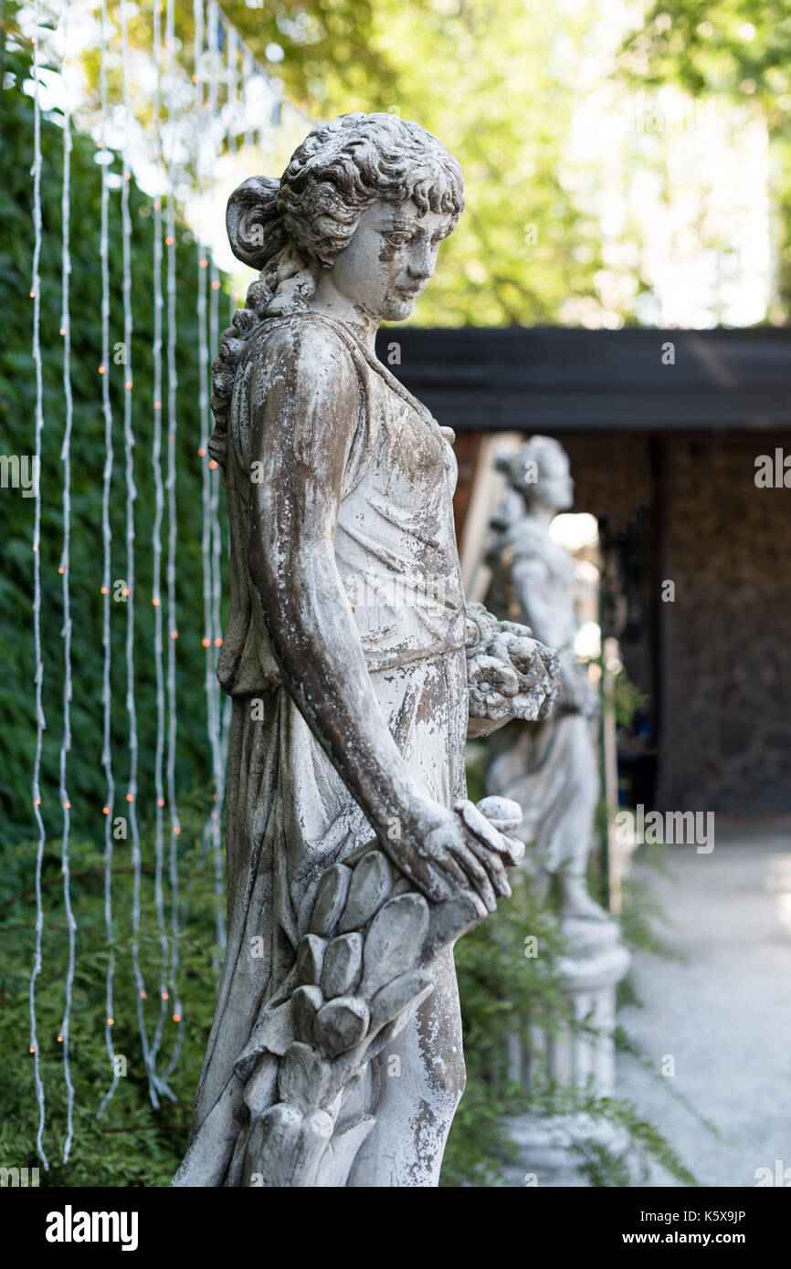 Statua in marmo Donna con cesto di fiori nel parco Foto stock - Alamy