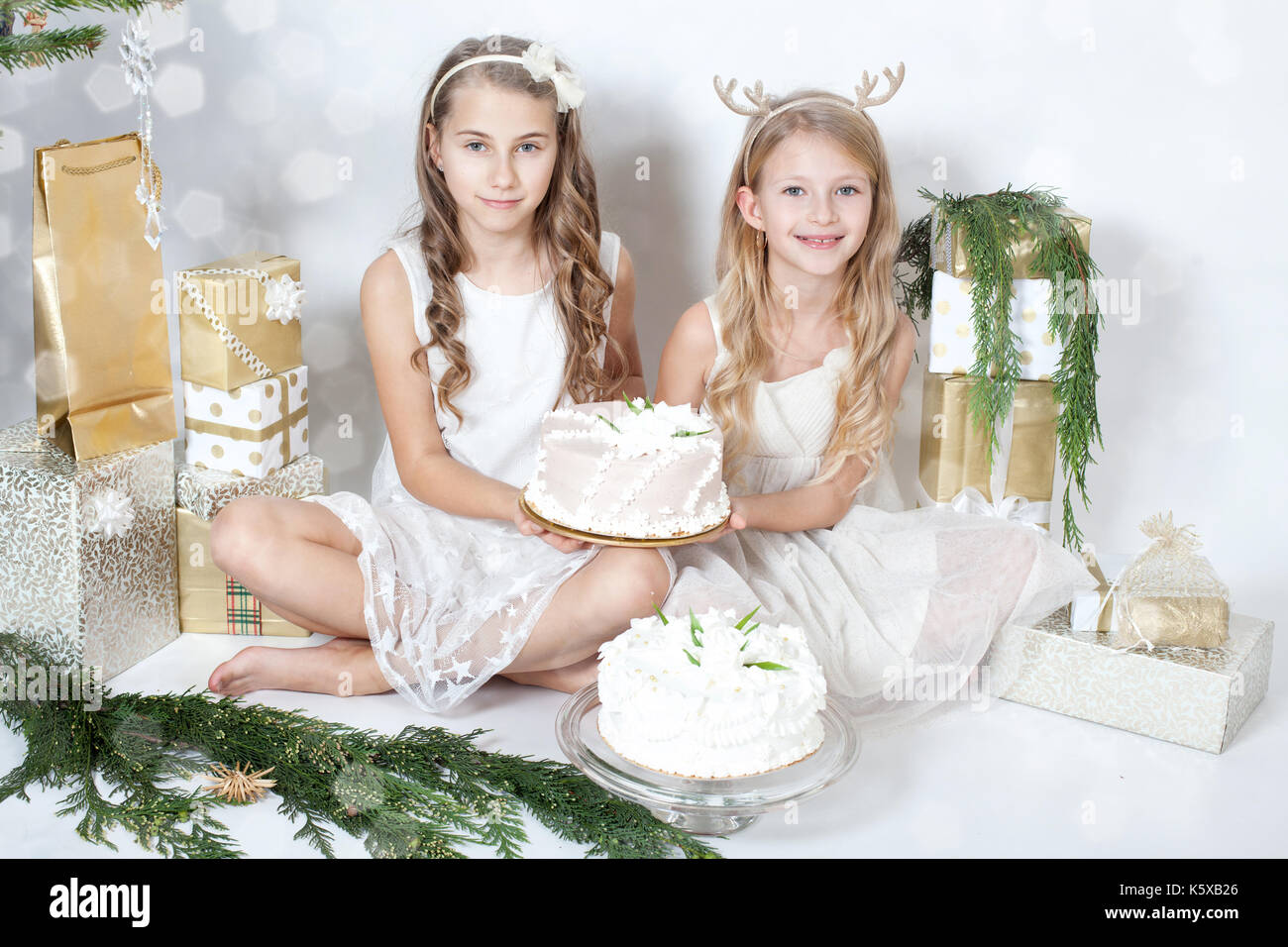 Belle ragazze tenendo una torta tra i doni Foto Stock