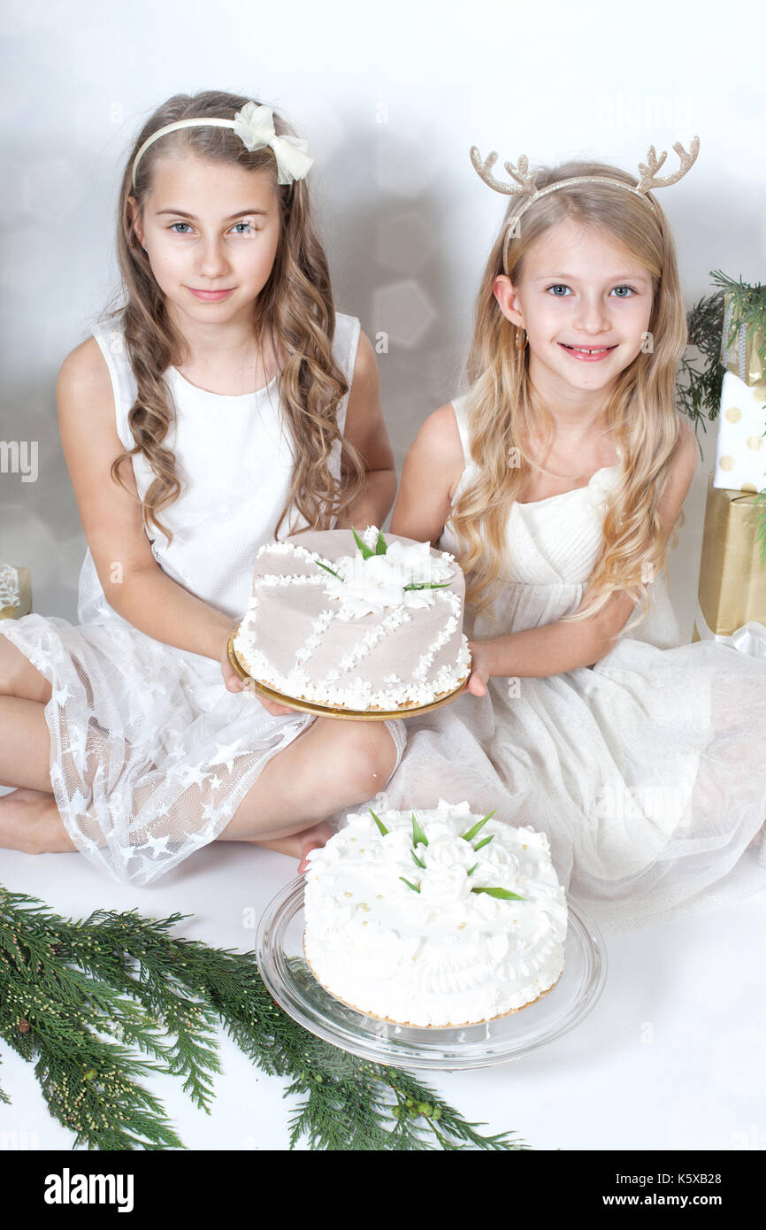 Belle ragazze tenendo una torta tra i doni Foto Stock