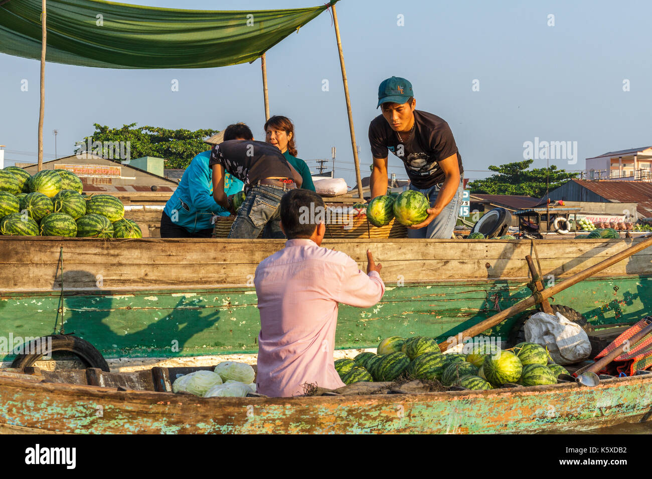 Can Tho, vietnam - 3/24/2016: un commerciante vende anguria a un re-venditore al cai rang mercato galleggiante sul fiume Mekong. Foto Stock