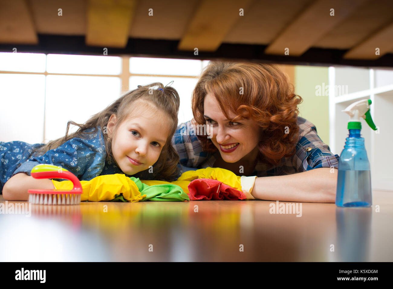 Madre e figlia fare pulizia in casa. Felice donna e bambino ragazza asciugò il pavimento. Foto Stock