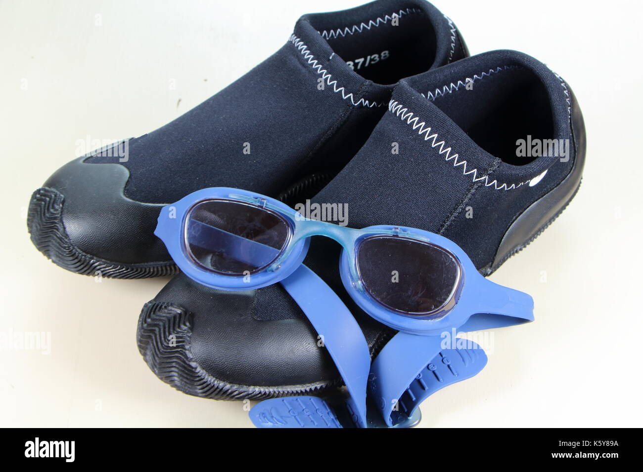 Blue occhiali da nuoto sopra nero avvio di nuoto Foto Stock