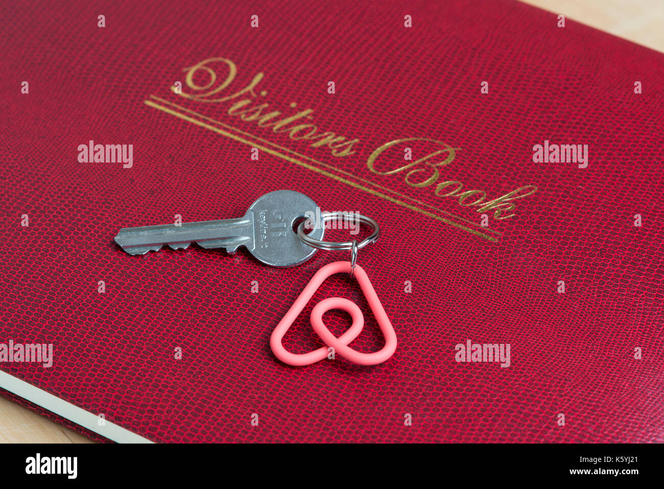 Un portachiavi con la Airbnb Belo logo poggia su un' degli ospiti libro degli ospiti in un appartamento disponibile per il noleggio. Foto Stock