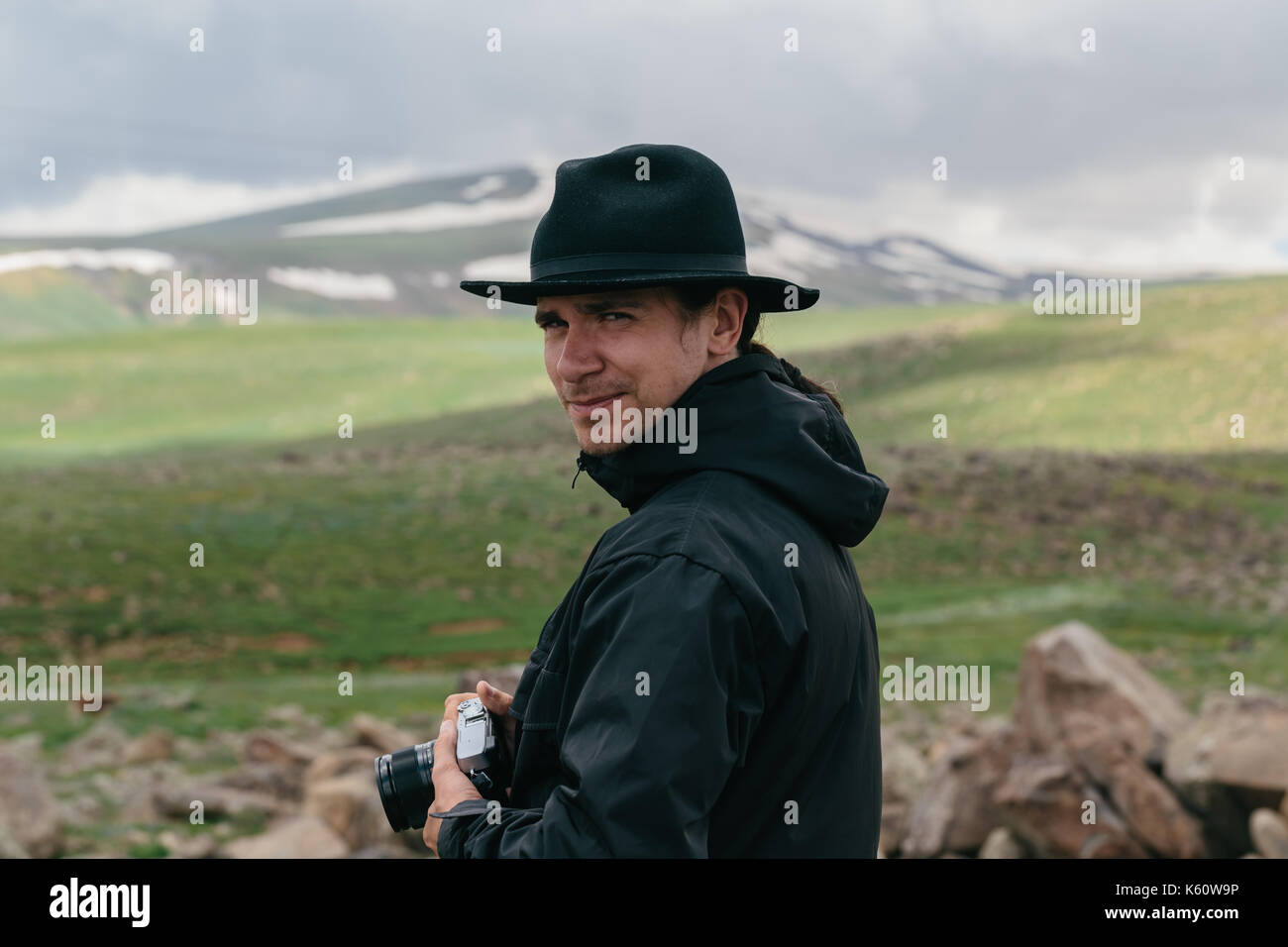 Il fotografo può contenere una fotocamera nelle mani delle montagne armene. Foto Stock