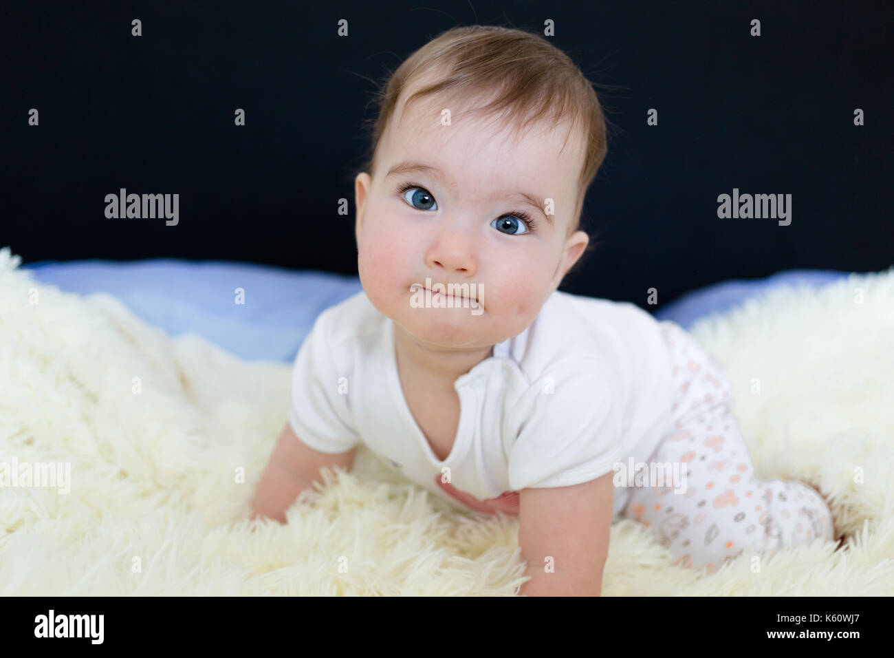 Bella blu eyed little baby sul letto. Foto Stock