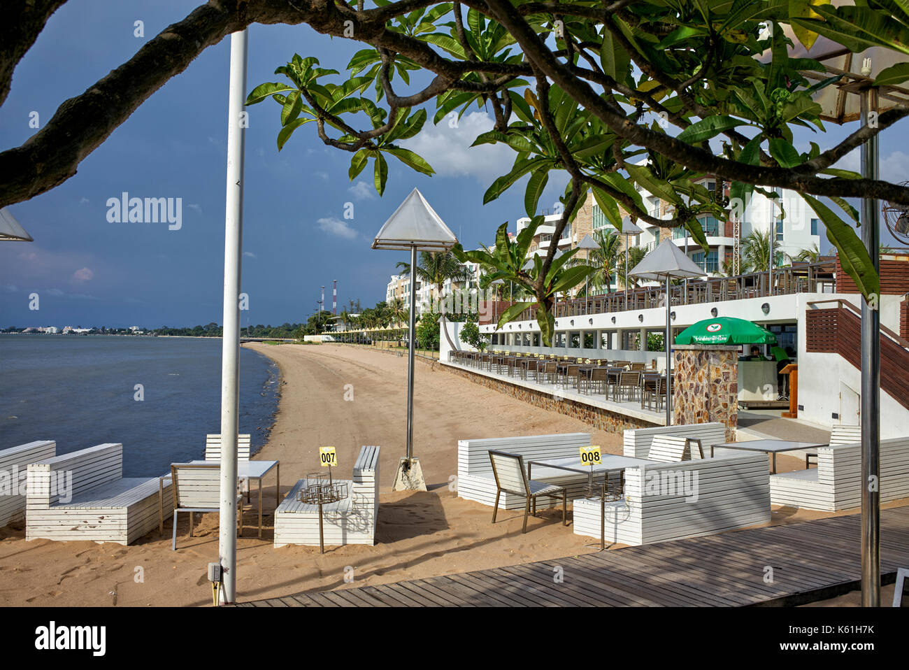 Area ristorante del resort sulla spiaggia Thailandese con tavoli e sedie che si affacciano sull'oceano. Pattaya, Thailandia, Sud-Est Asiatico Foto Stock