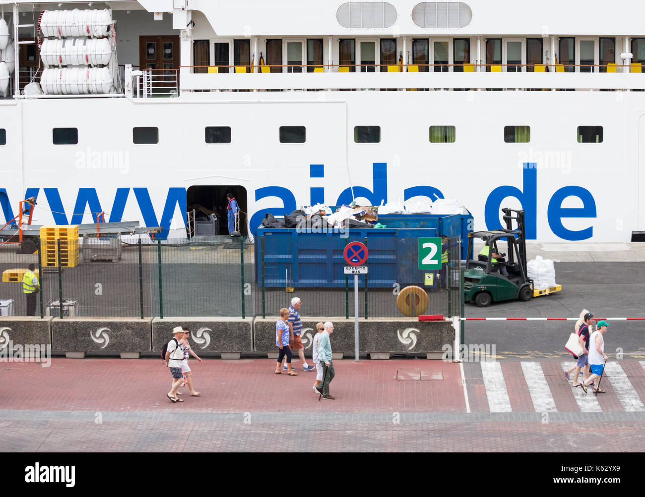 Rifiuti da grande nave da crociera essendo caricato in contenitori in porta come passeggeri visitare siti locali. Foto Stock