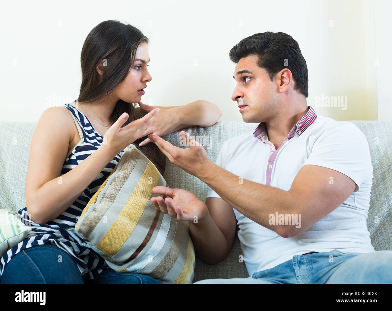 Conversazione seria tra il marito e la sua attraente longhaired giovane moglie a casa Foto Stock