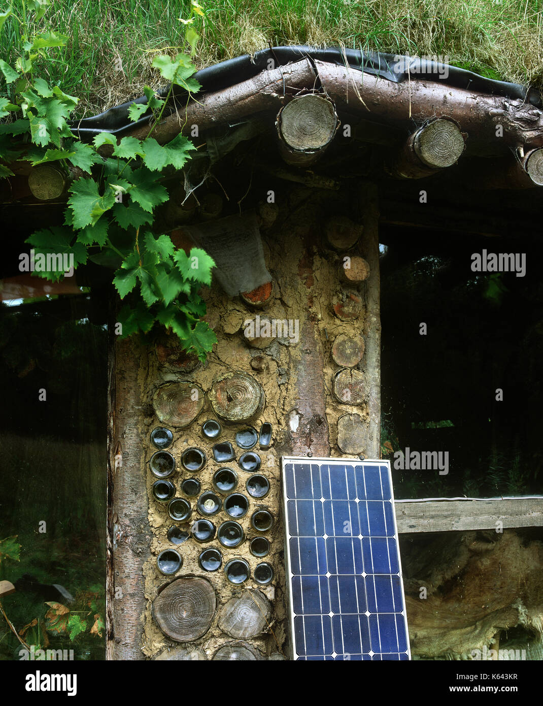 Close up di materiali da costruzione (compresi turf, legno e bottiglie vuote) e celle fotovoltaiche al Roundhouse, brithdir mawr eco-villaggio, il Galles. Foto Stock