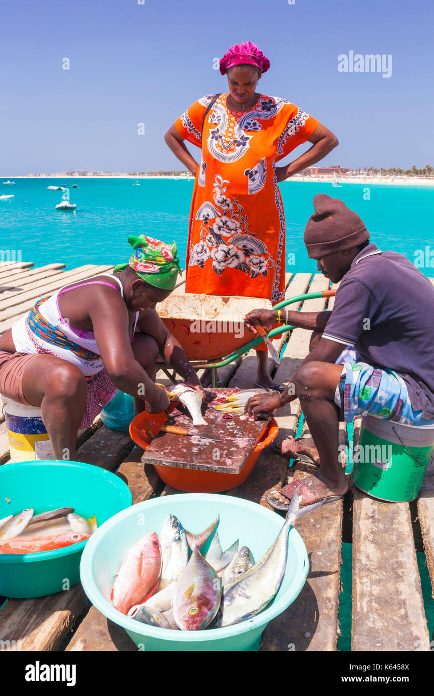 Capo Verde SAL la popolazione locale la scalatura e eviscerazione del pesce appena pescato pronti per la vendita sul molo in legno in Santa Maria Isola di Sal Capo verde Africa Foto Stock