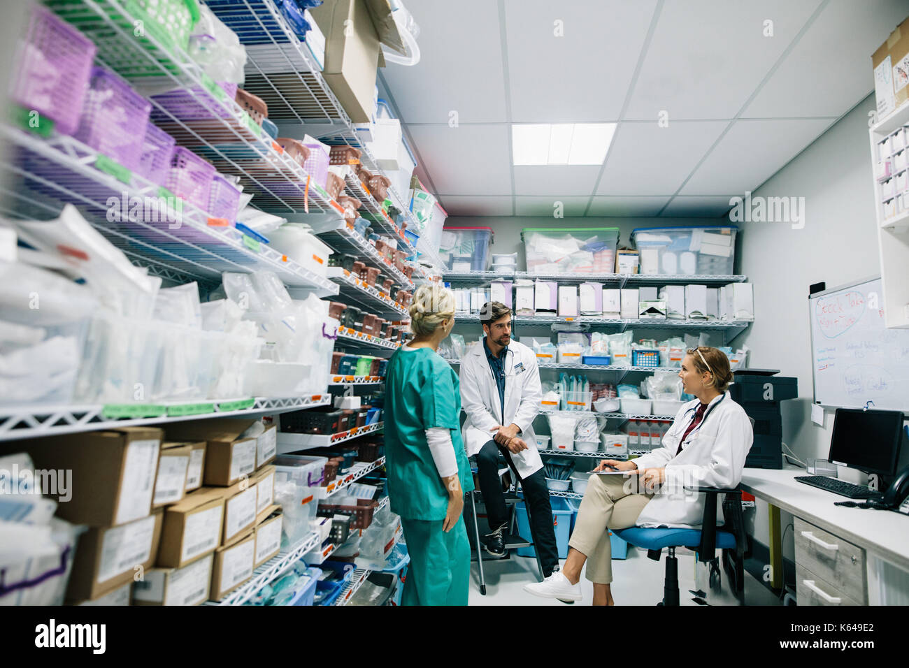 Il personale medico discute in farmacia ospedaliera. Medici e infermieri parlando in farmacia ospedaliera. Foto Stock