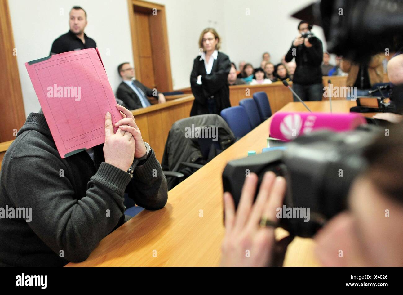 L'ex infermiere niels h., accusato di omicidio multiplo e attmepted assassinio di pazienti, nell'aula del tribunale indossando le manette e che copre la sua faccia con un file presso la corte distrettuale di Oldenburg (Germania), 19 febbraio 2015. | Utilizzo di tutto il mondo Foto Stock