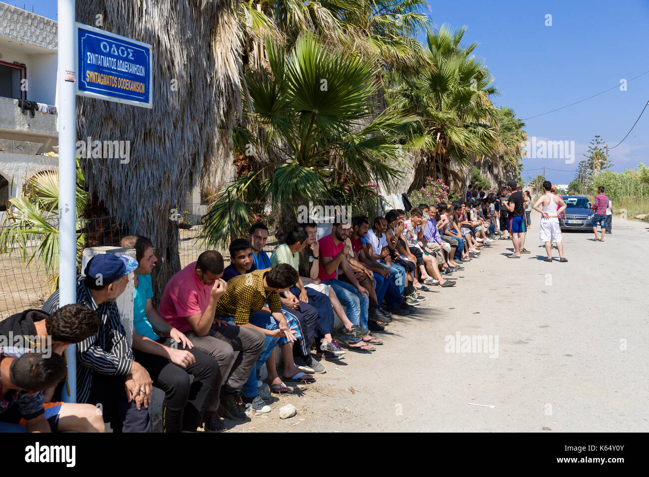 Grecia Isola di Kos, su 2015/06/13. I migranti aspettare che la gente ci dia cibo davanti al abbandonato "Capitano Elias' hotel, ora il rifugio di h Foto Stock