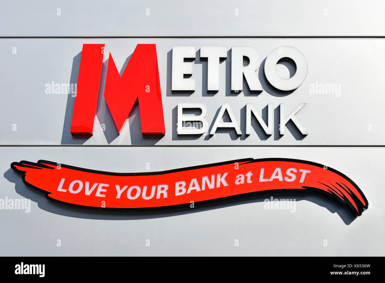 Metro Bank logo e slogan amore la vostra banca sulla parete della nuova filiale bancaria edificio in Romford Havering Est Londra Inghilterra REGNO UNITO Foto Stock