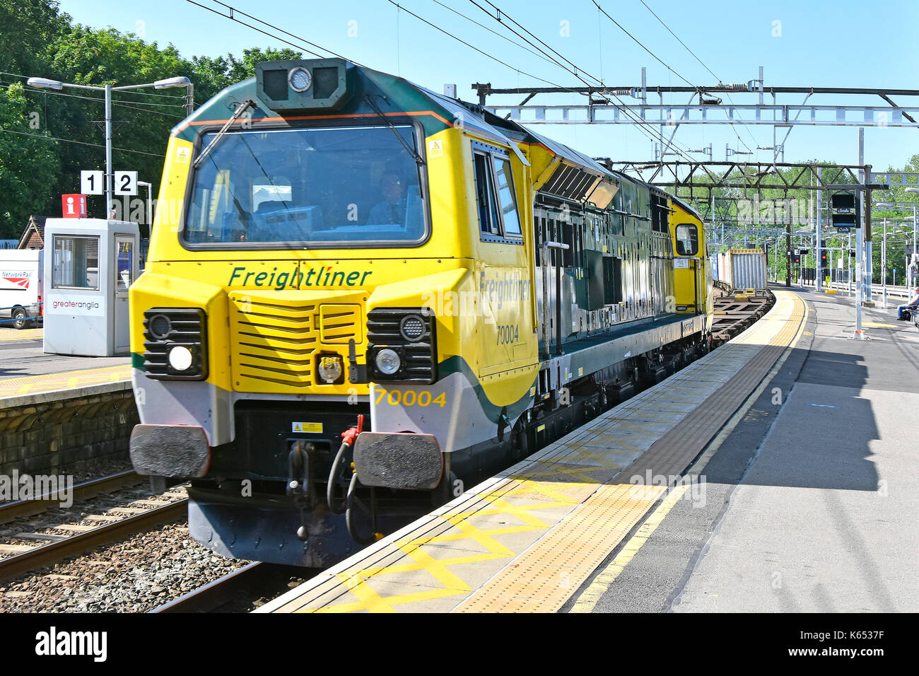 Freightliner mainline freight elettrica diesel loco 70004 parte caricati con i contenitori di spedizione con alcuni carri vuoti passando attraverso Shenfield station Foto Stock