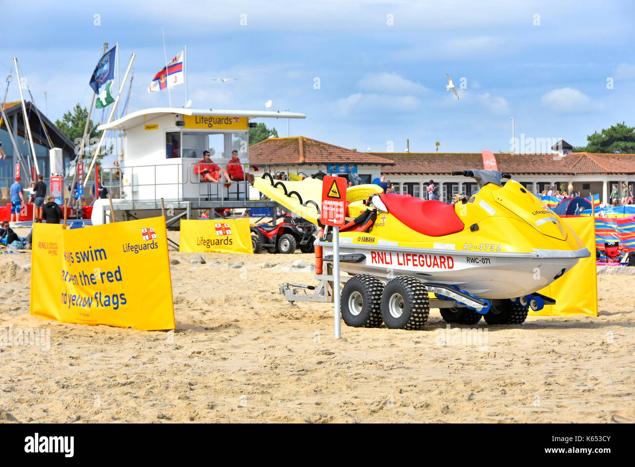 Presidiati RNLI stazione bagnino sulla popolare barene seaside beach Dorset UK occupato durante la scuola estiva stagione di vacanze con equipaggiamento di salvataggio e avvisi Foto Stock