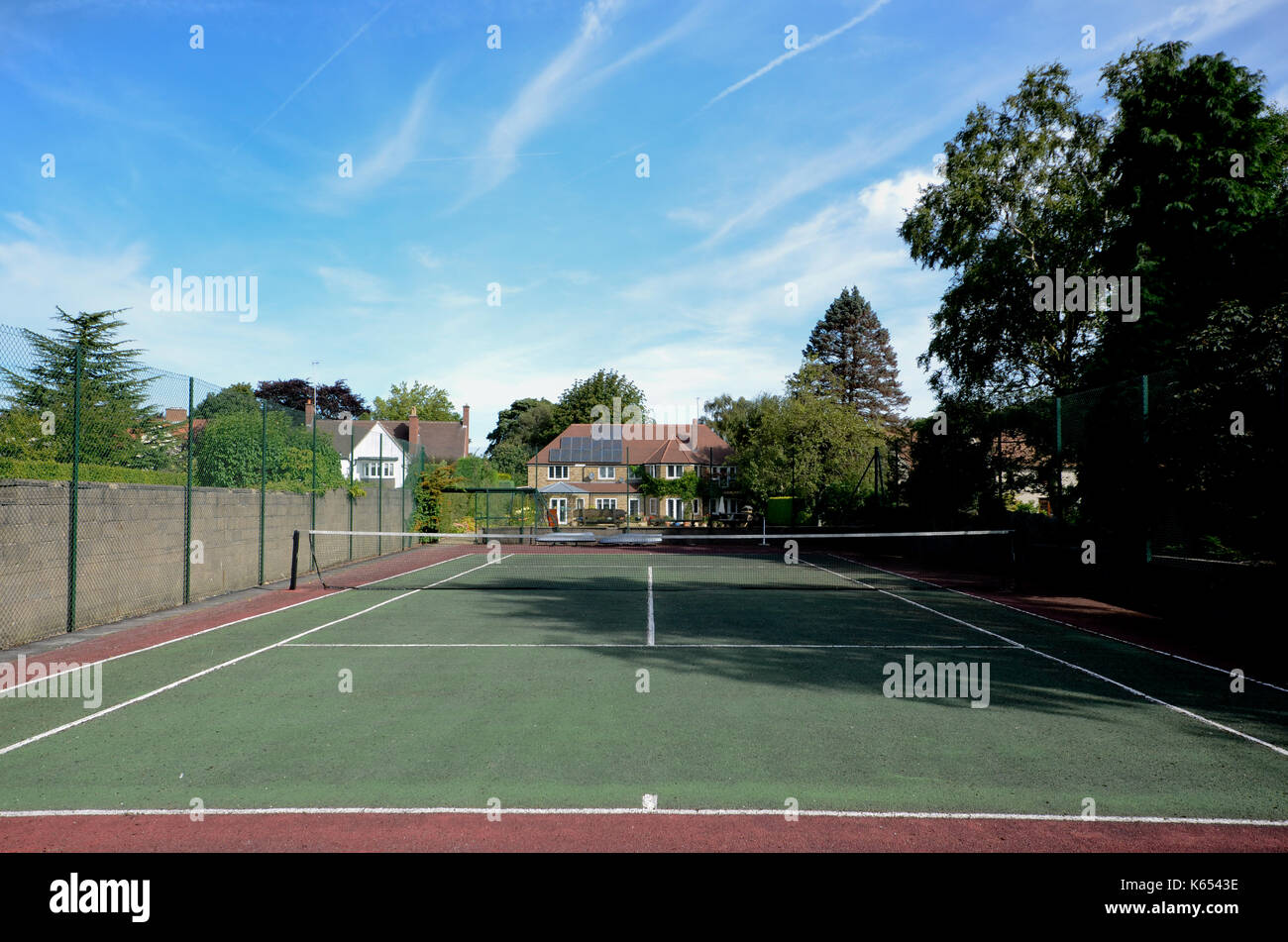 Campo da tennis con executive house e cielo blu Foto Stock
