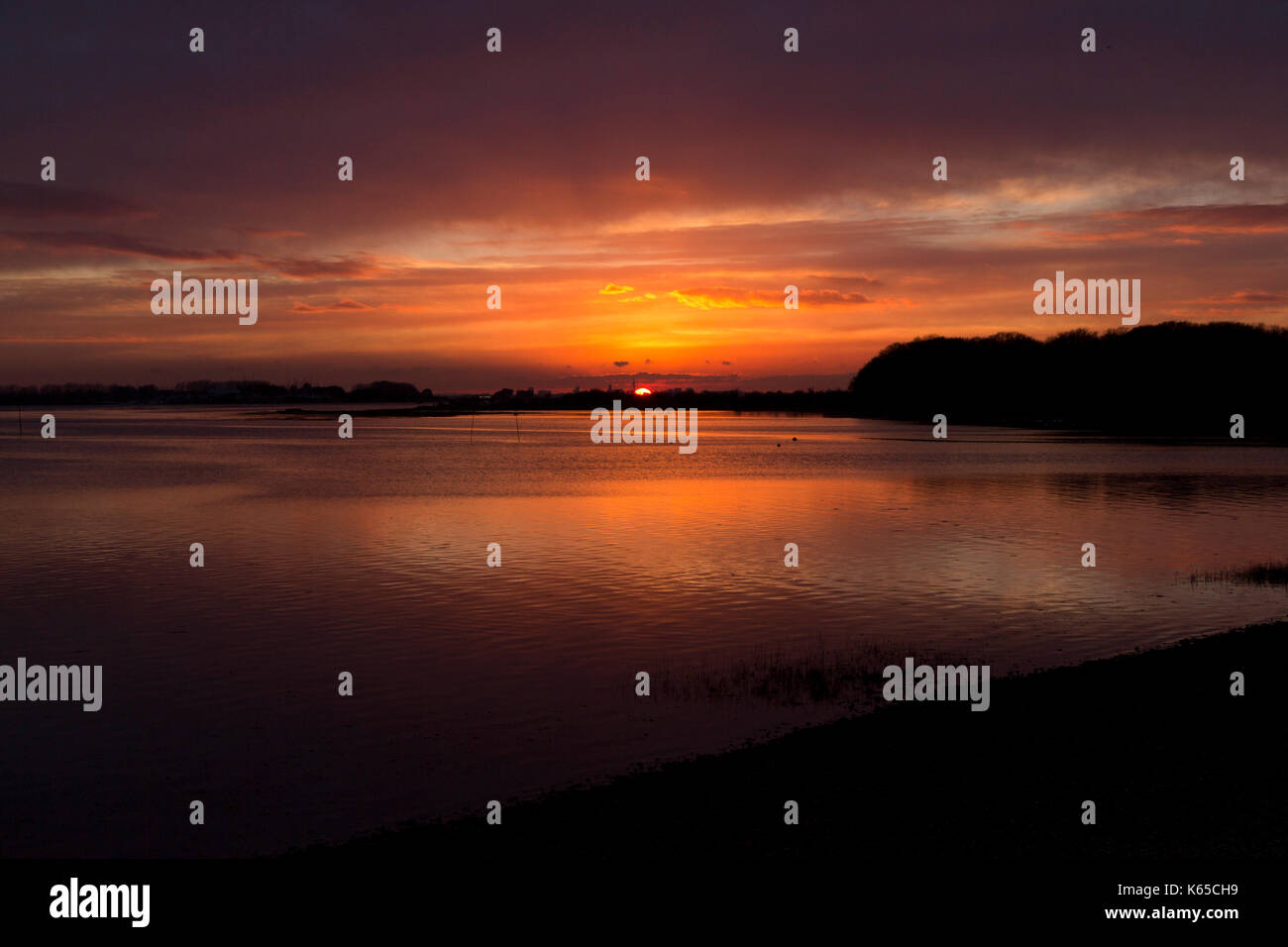 Inglese vista costiera al tramonto con acqua scintillante Foto Stock