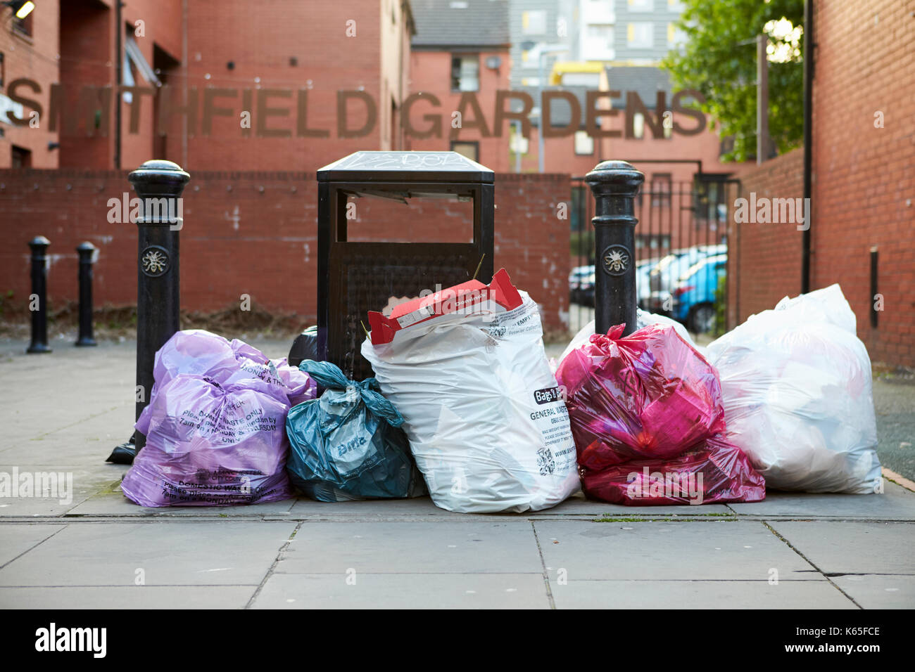 Manchester, Regno Unito - 10 Maggio 2017: sacchi di rifiuti ammucchiati accanto al vassoio sul Manchester Street Foto Stock